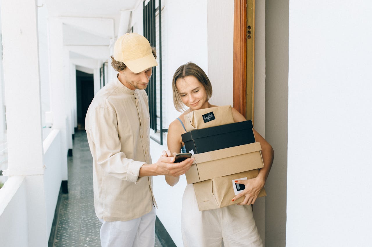 services-img A man and woman engaged in a home delivery package exchange, smiling.